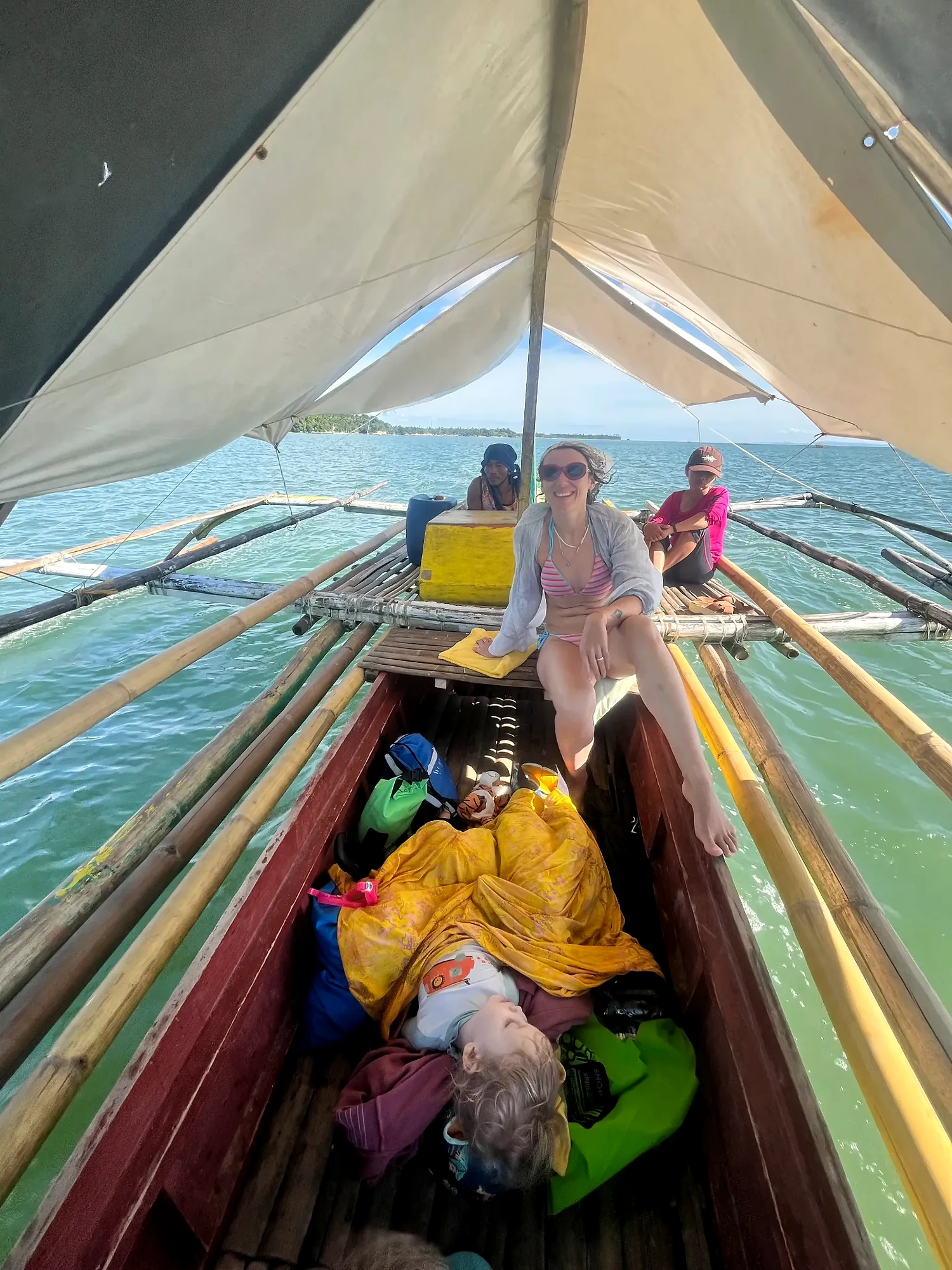 Family resting on a bangka during the return journey across Pilar Bay